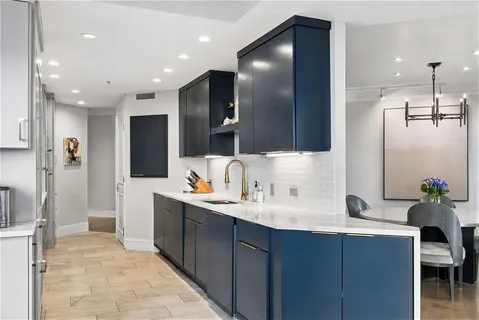 a large kitchen with stainless steel appliances a sink stove and cabinets