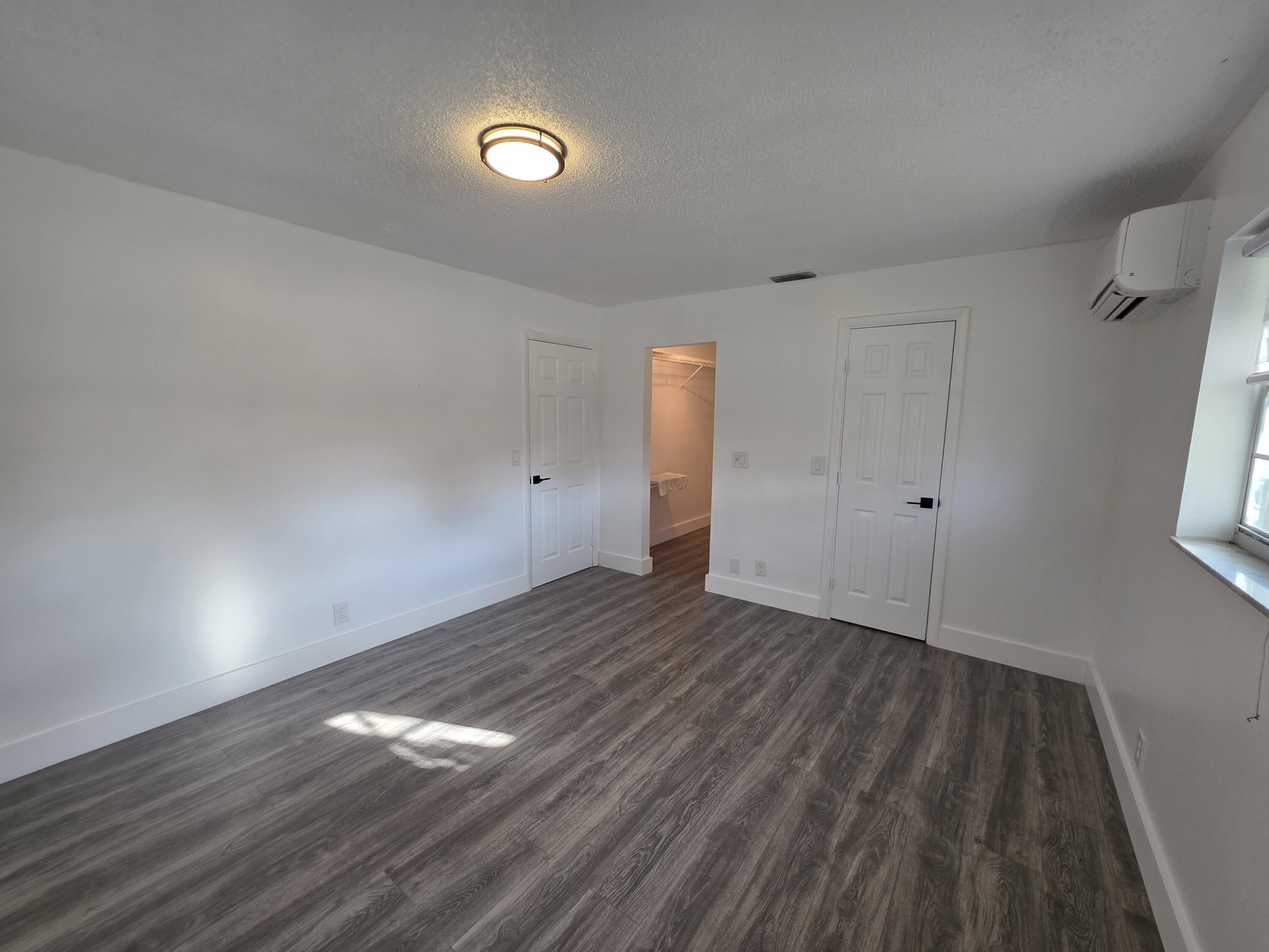 718 Whippoorwill Lane Delray Beach, FL 33445 - Photo 15 of 38 a view of empty room with wooden floor and fan