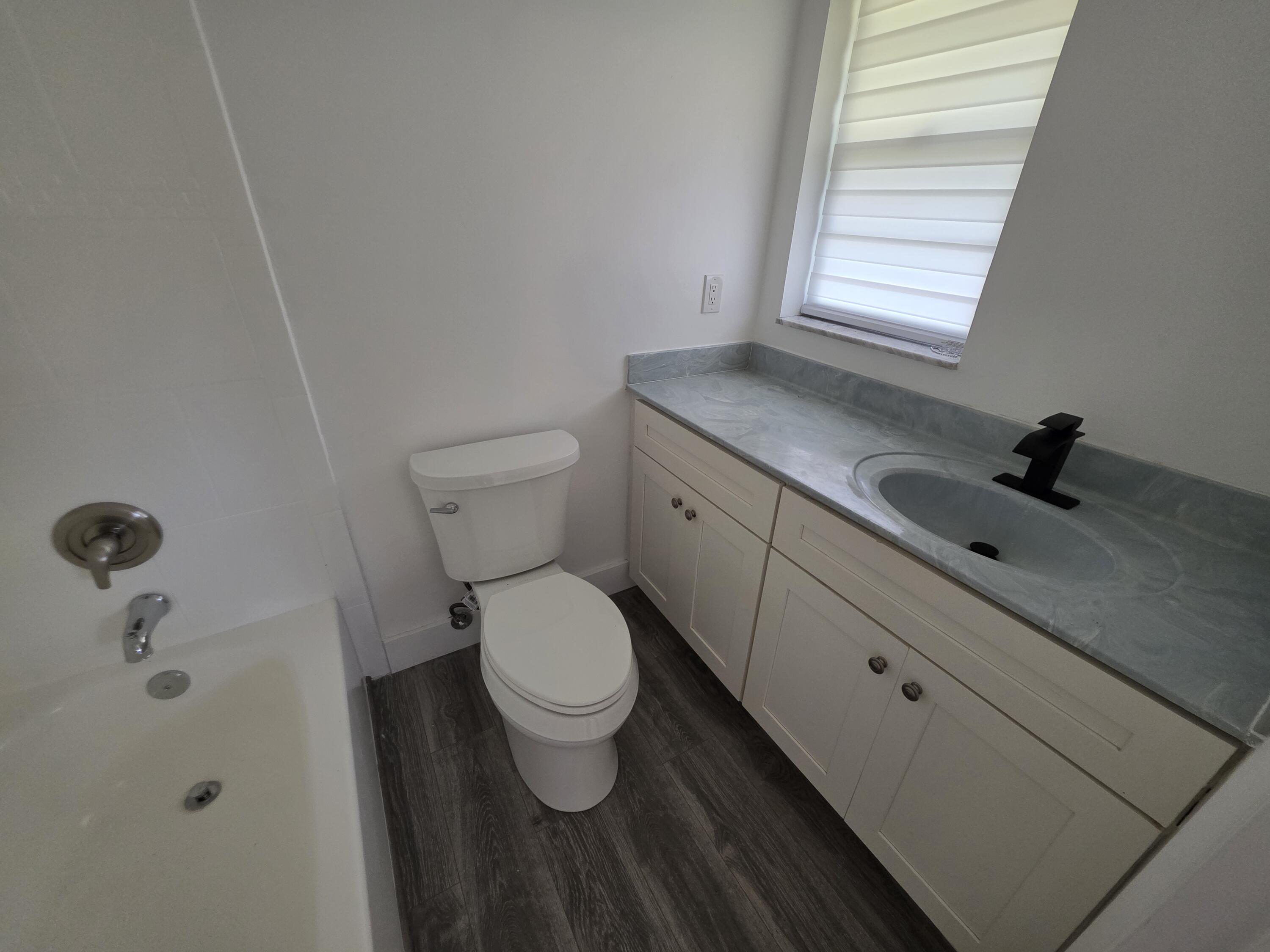 718 Whippoorwill Lane Delray Beach, FL 33445 - Photo 18 of 38 a bathroom with a sink and a toilet