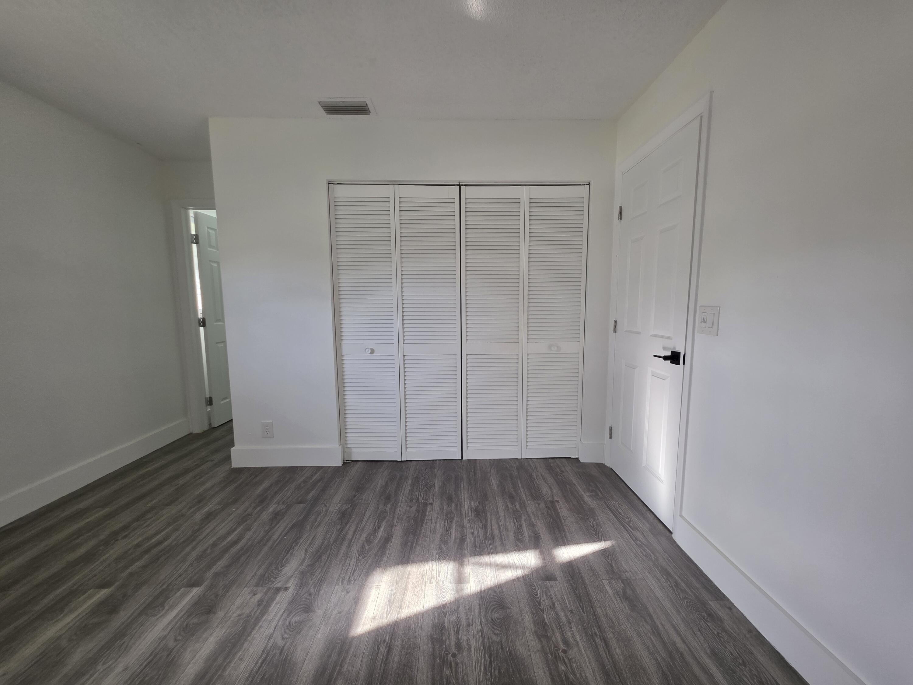 718 Whippoorwill Lane Delray Beach, FL 33445 - Photo 21 of 38 a view of a room with wooden floor and white walls