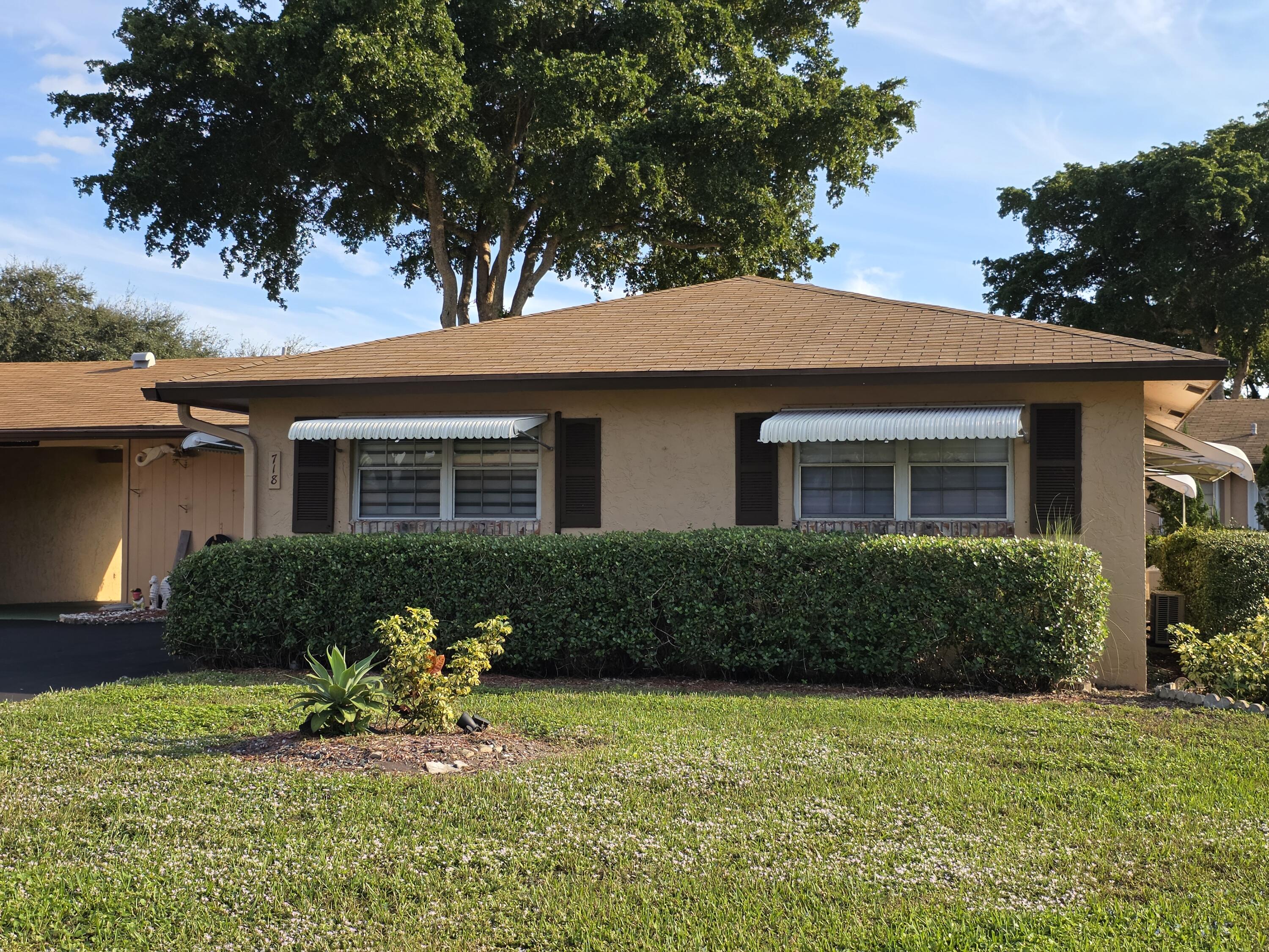 718 Whippoorwill Lane Delray Beach, FL 33445 - Photo 4 of 38 a front view of a house with garden
