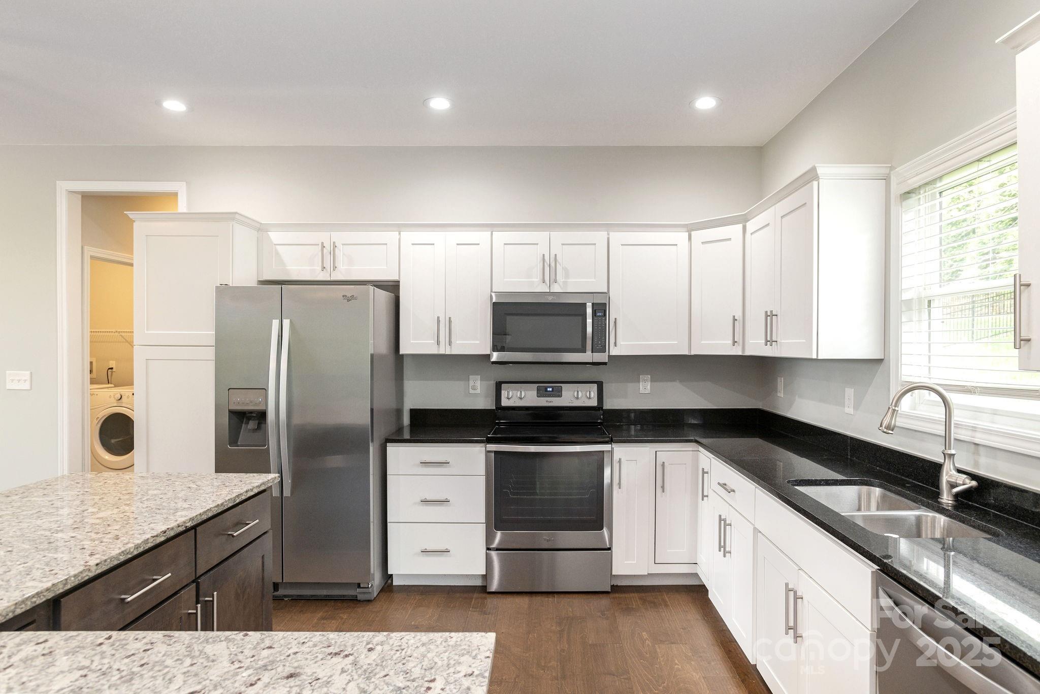 76 Tryon View Drive Flat Rock, NC 28731 - Photo 12 of 30 a kitchen with stainless steel appliances granite countertop a sink a stove a refrigerator a counter space and cabinets