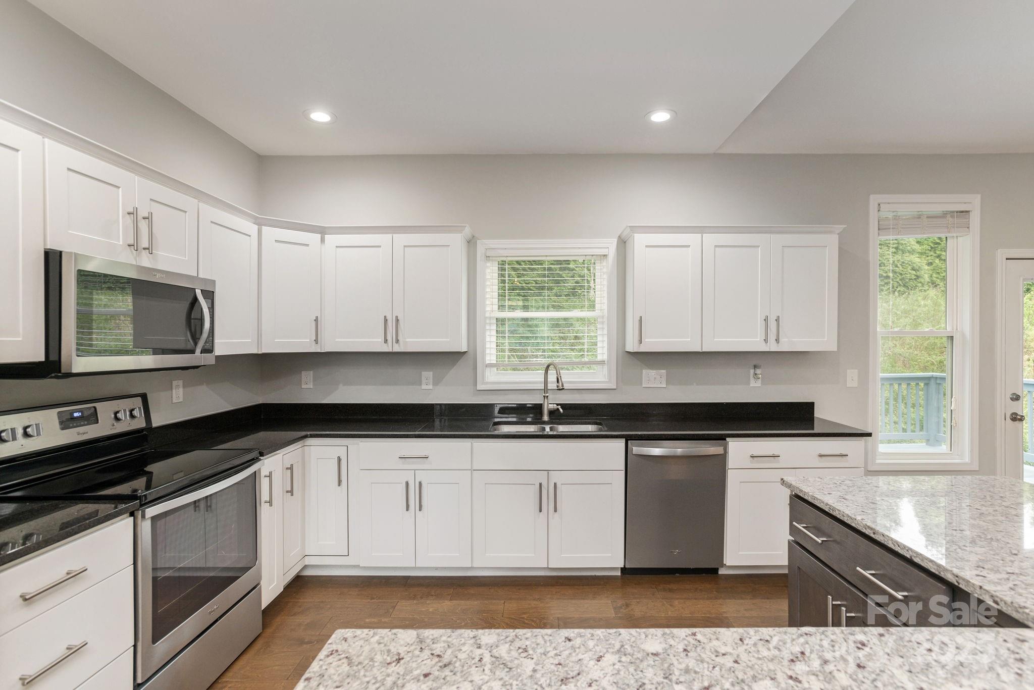 76 Tryon View Drive Flat Rock, NC 28731 - Photo 14 of 30 a large kitchen with stainless steel appliances granite countertop a stove a sink and a microwave