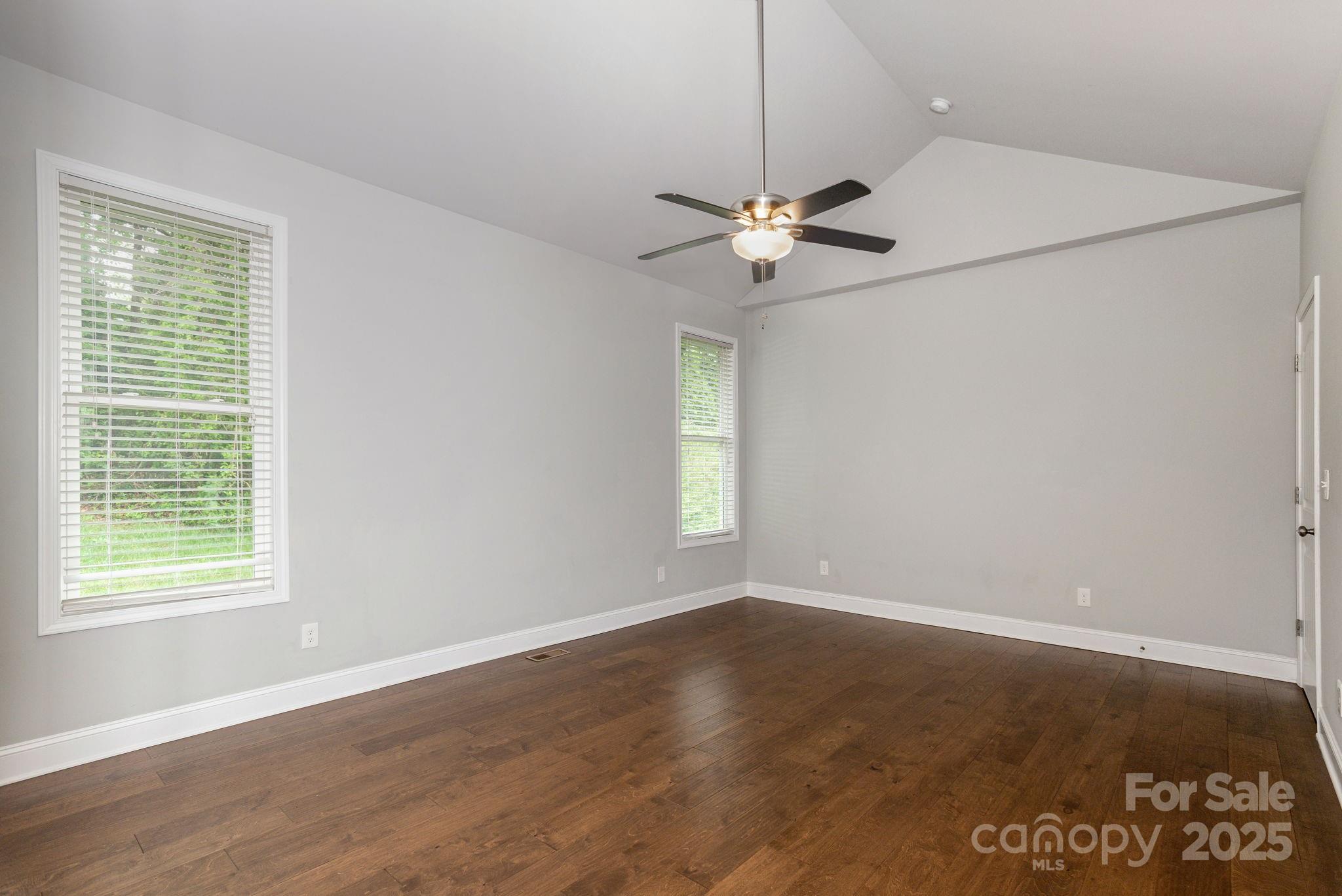 76 Tryon View Drive Flat Rock, NC 28731 - Photo 17 of 30 an empty room with wooden floor chandelier fan and windows