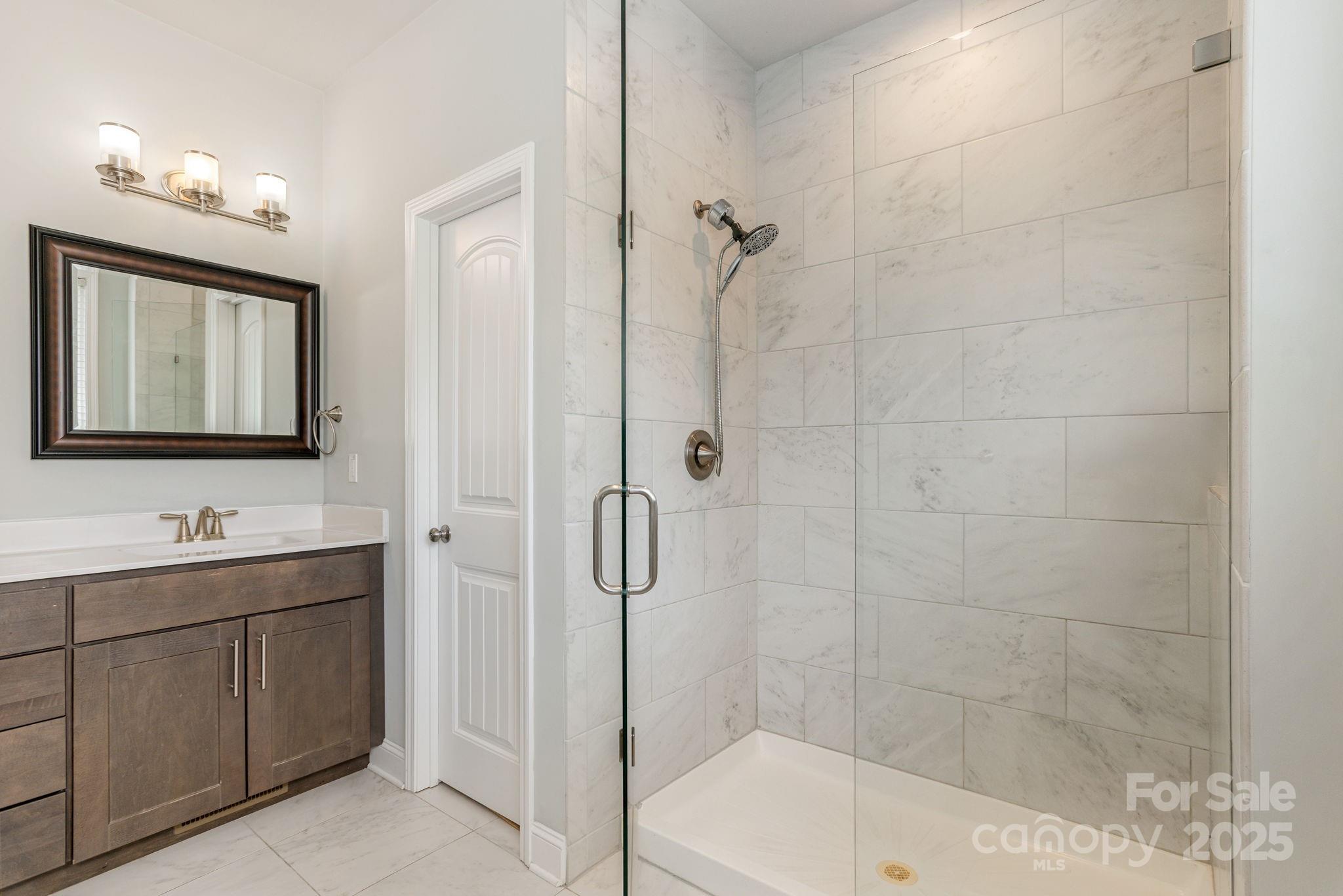 76 Tryon View Drive Flat Rock, NC 28731 - Photo 20 of 30 a bathroom with a shower a sink and mirror