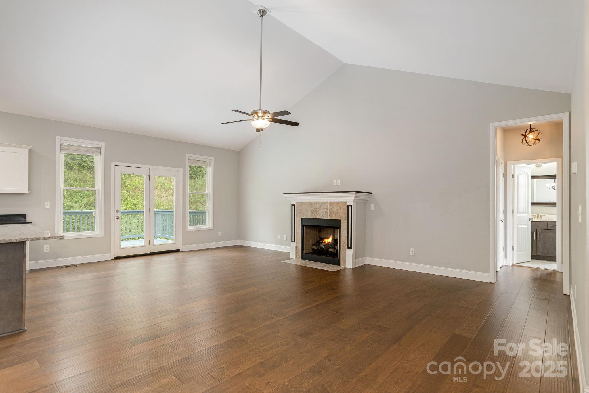 76 Tryon View Drive Flat Rock, NC 28731 - Photo 7 of 30 a view of an empty room with wooden floor fireplace and a window