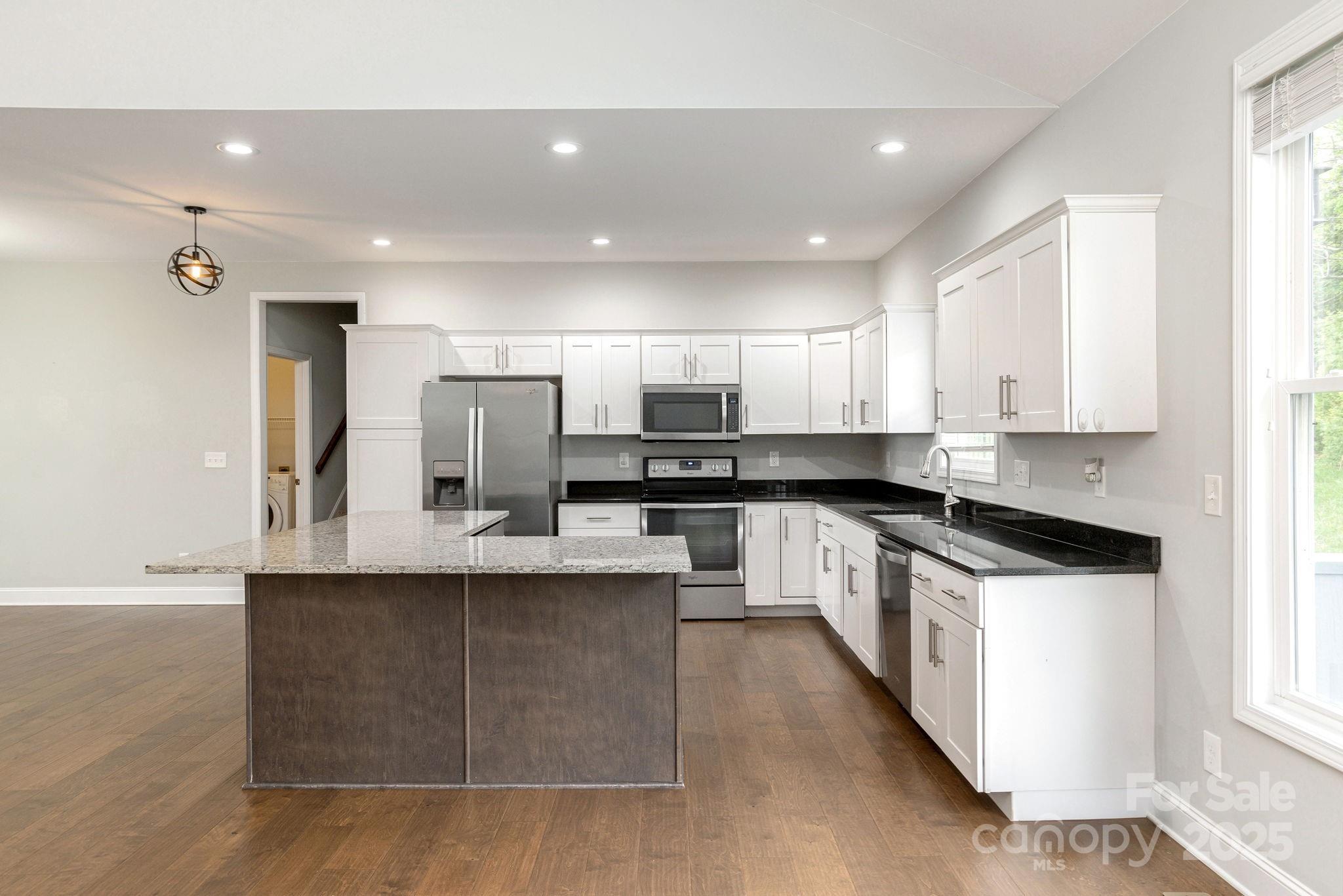 76 Tryon View Drive Flat Rock, NC 28731 - Photo 10 of 30 a large kitchen with stainless steel appliances kitchen island granite countertop a sink and cabinets