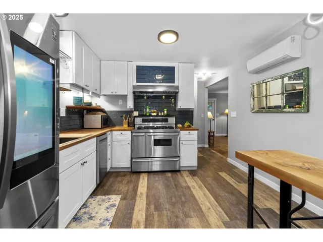 a kitchen with granite countertop a refrigerator stove top oven and sink