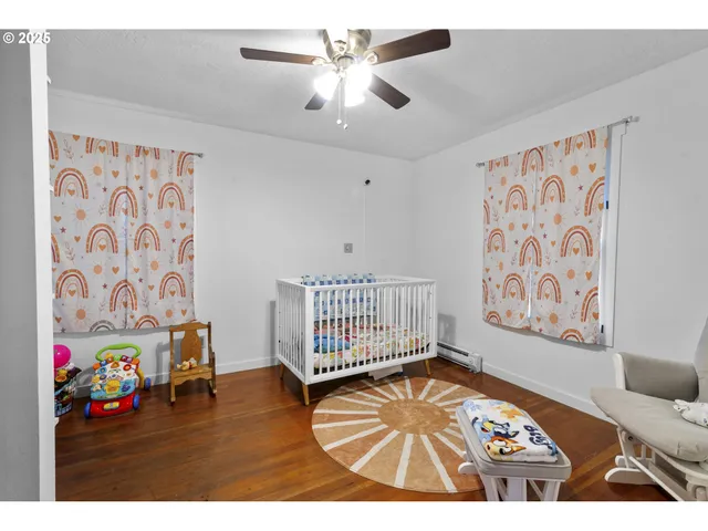 a view of a bedroom with furniture and wooden floor