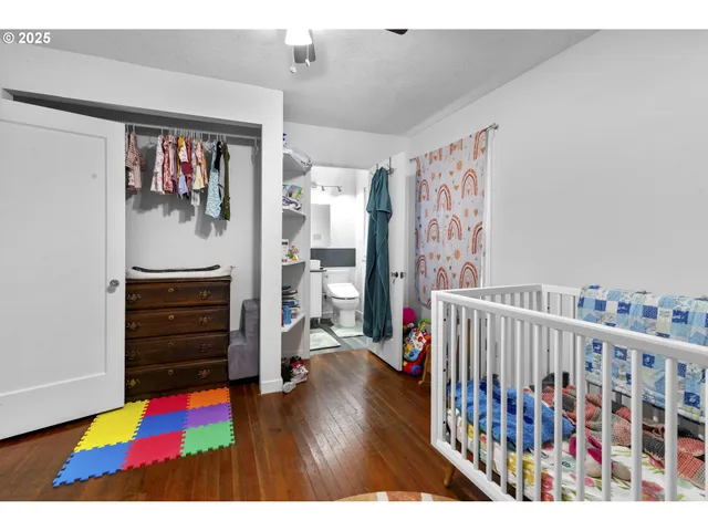 a view of a bedroom with baby crib and toys
