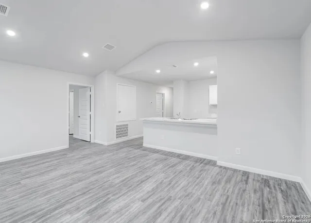 a view of an empty room with wooden floor