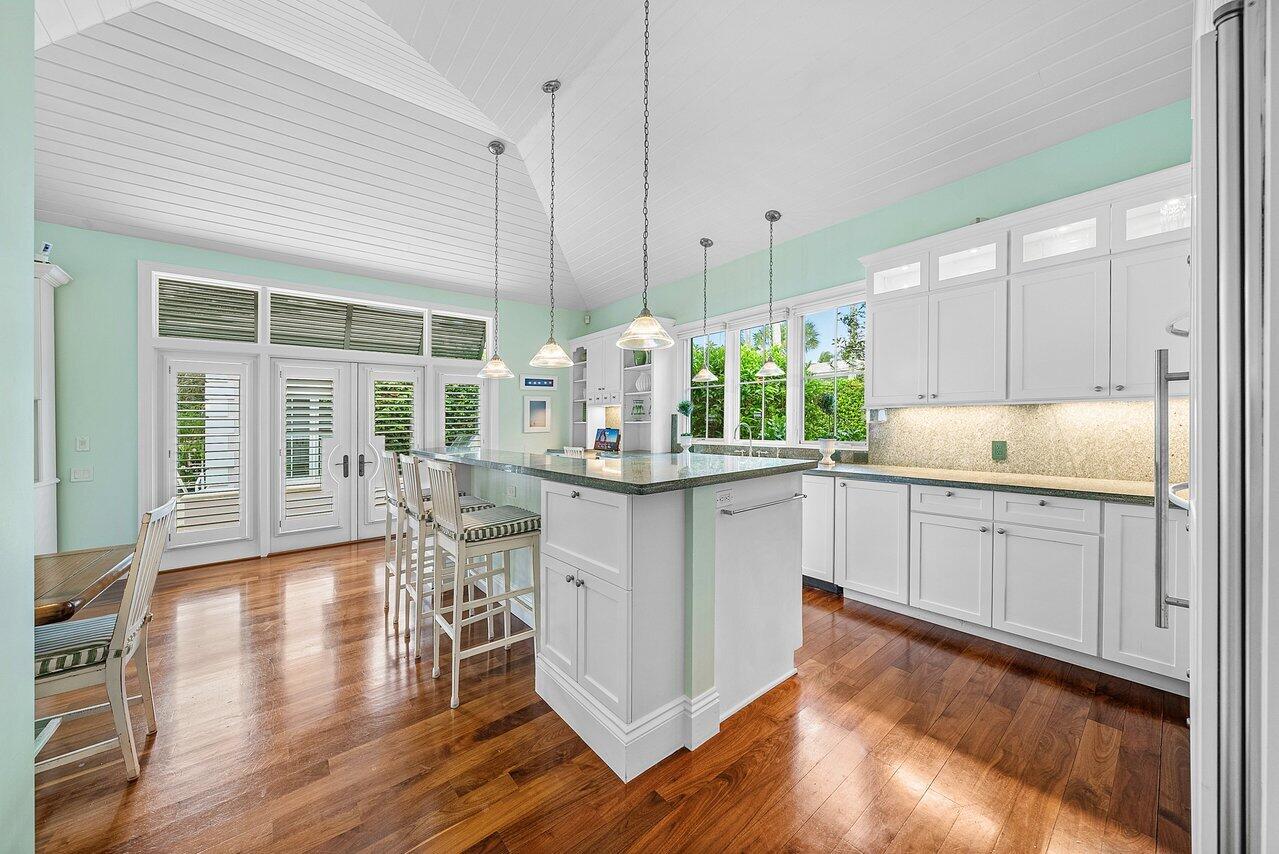 3138 Gulf Stream Road Gulf Stream, FL 33483 - Photo 11 of 49 a kitchen with kitchen island granite countertop wooden floors and white cabinets
