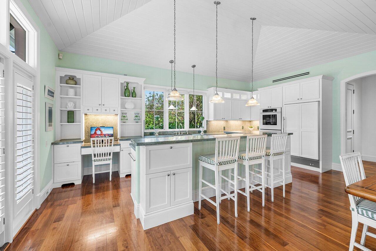 3138 Gulf Stream Road Gulf Stream, FL 33483 - Photo 12 of 49 a kitchen with stainless steel appliances white cabinets and wooden floors