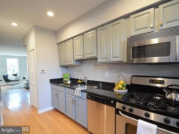 a kitchen with stainless steel appliances granite countertop a sink stove and cabinets