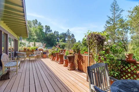 a view of a chairs and table on the wooden deck