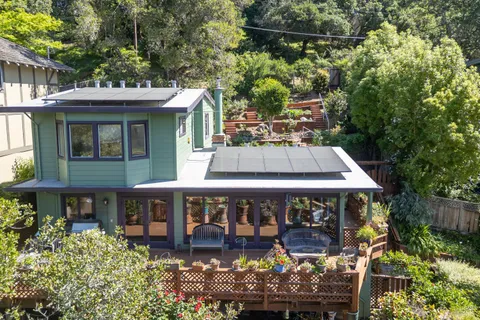 a view of a house with wooden deck and furniture