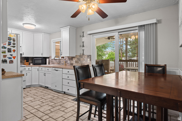 7659 State Street Midvale, UT 84047 - Photo 6 of 33 Kitchen featuring white cabinetry, light-toned countertops, and a tiled backsplash