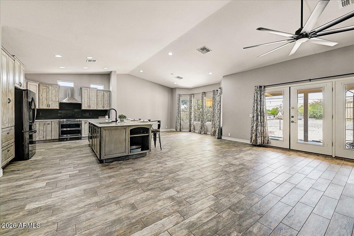 7624 North Citrus Road Waddell, AZ 85355 - Photo 11 of 57 a view of kitchen with stainless steel appliances granite countertop a stove top oven a sink dishwasher a refrigerator and white cabinets with wooden floor
