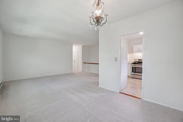 wooden floor in an empty room with a chandelier