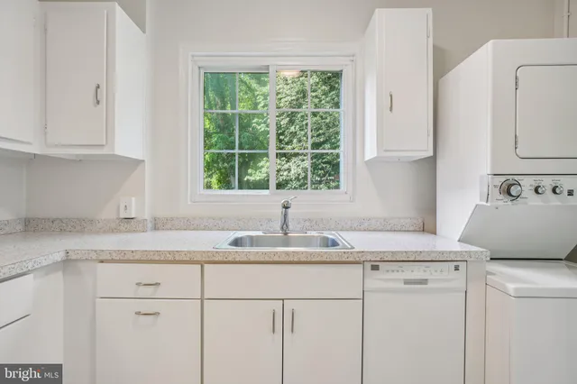a kitchen with granite countertop cabinets sink and window