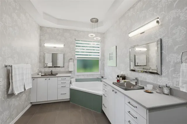 an aerial view of a residential houses with outdoor space and trees