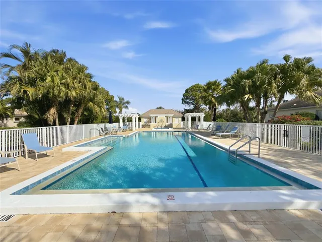 a view of a lake with a yard and large trees
