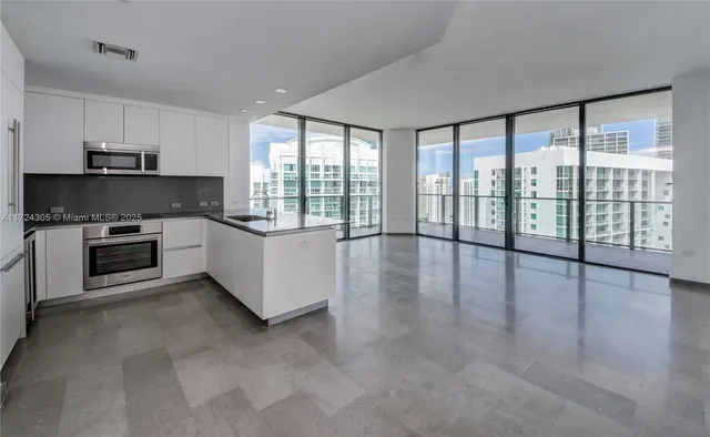 a view of a kitchen with kitchen island a sink and a large window