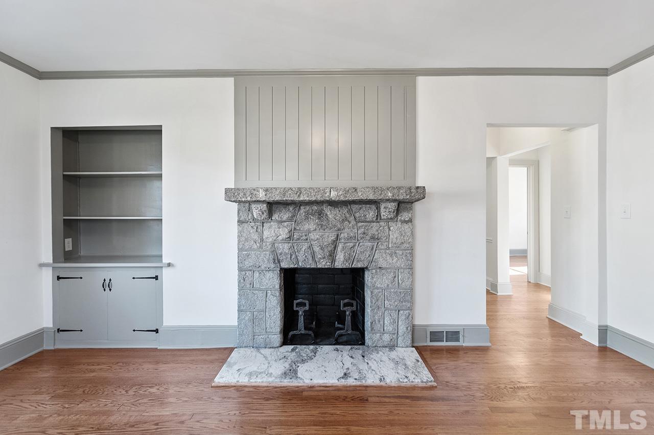 704 Dixie Trail Raleigh, NC 27607 - Photo 11 of 31 a view of empty room with wooden floor and fireplace