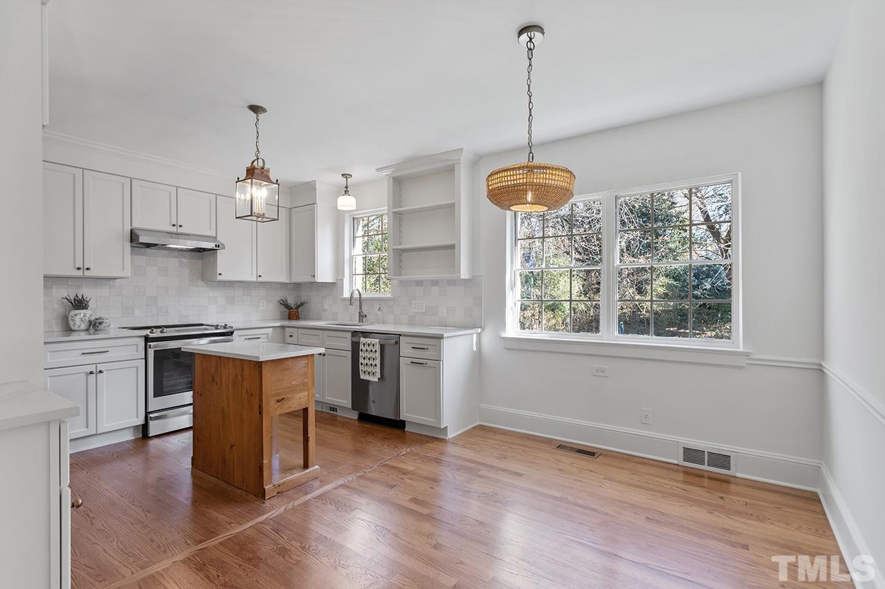 704 Dixie Trail Raleigh, NC 27607 - Photo 12 of 31 a kitchen with stainless steel appliances granite countertop a stove a sink dishwasher a refrigerator and a window with wooden floors