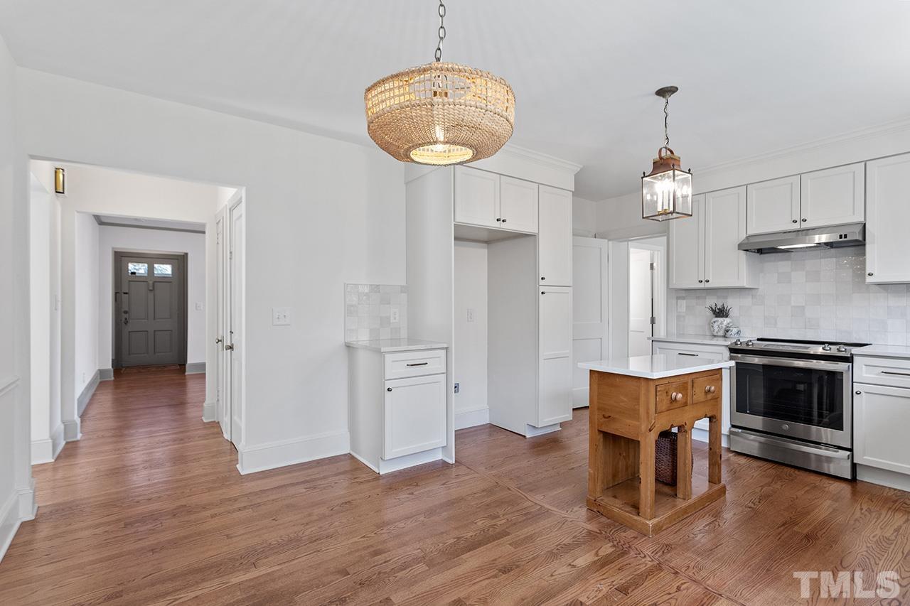 704 Dixie Trail Raleigh, NC 27607 - Photo 13 of 31 a kitchen with stainless steel appliances a stove and wooden floor