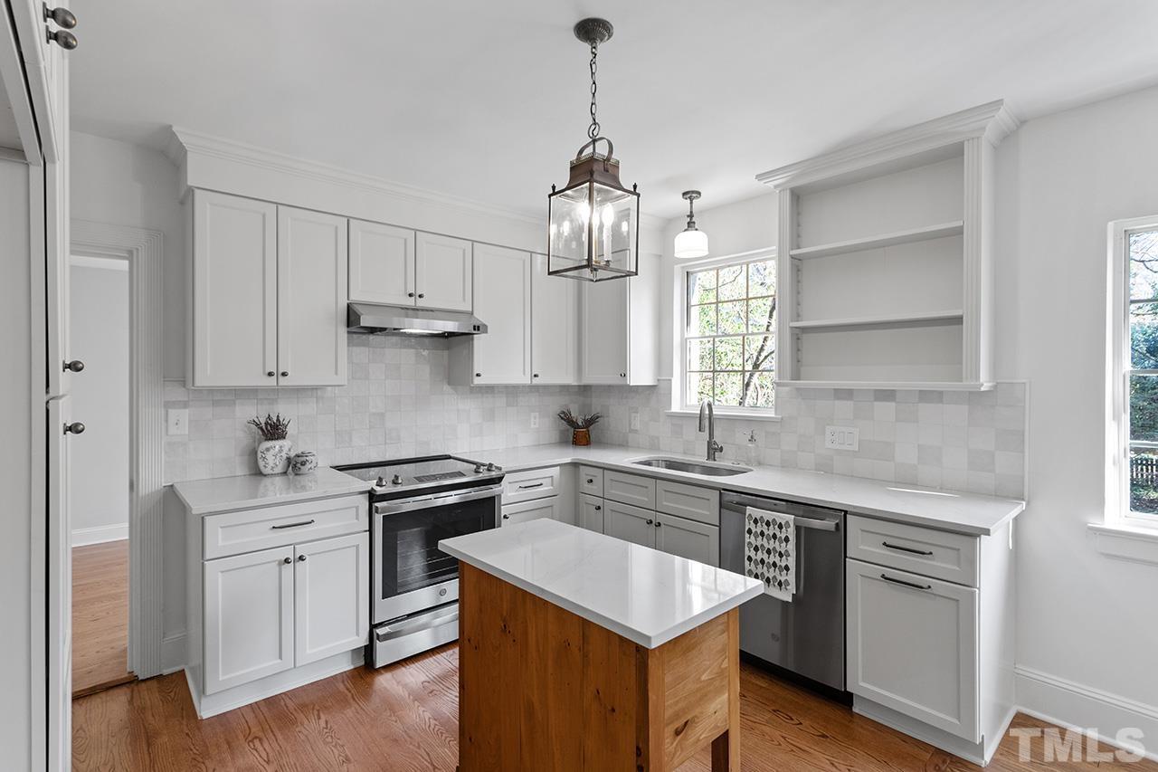 704 Dixie Trail Raleigh, NC 27607 - Photo 15 of 31 a kitchen with white cabinets stainless steel appliances and sink