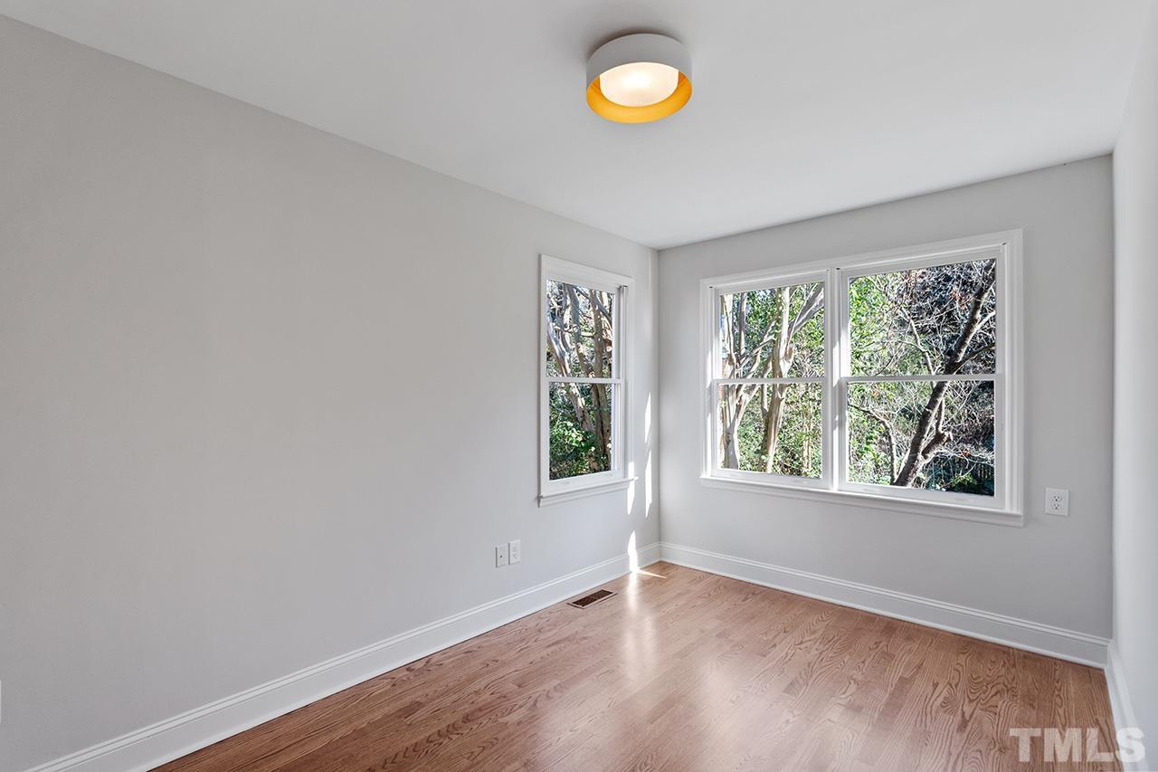 704 Dixie Trail Raleigh, NC 27607 - Photo 19 of 31 an empty room with wooden floor and windows
