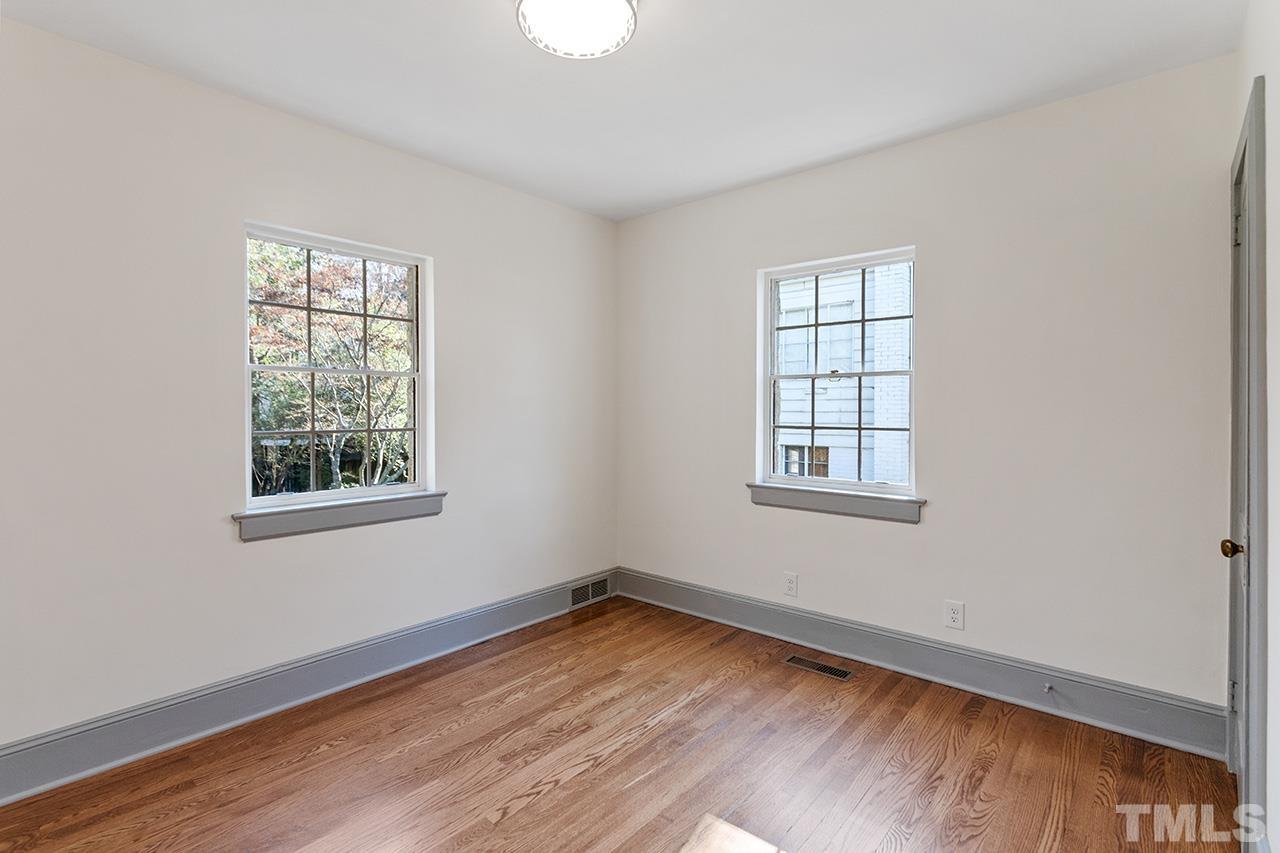 704 Dixie Trail Raleigh, NC 27607 - Photo 23 of 31 a view of an empty room with wooden floor and a window