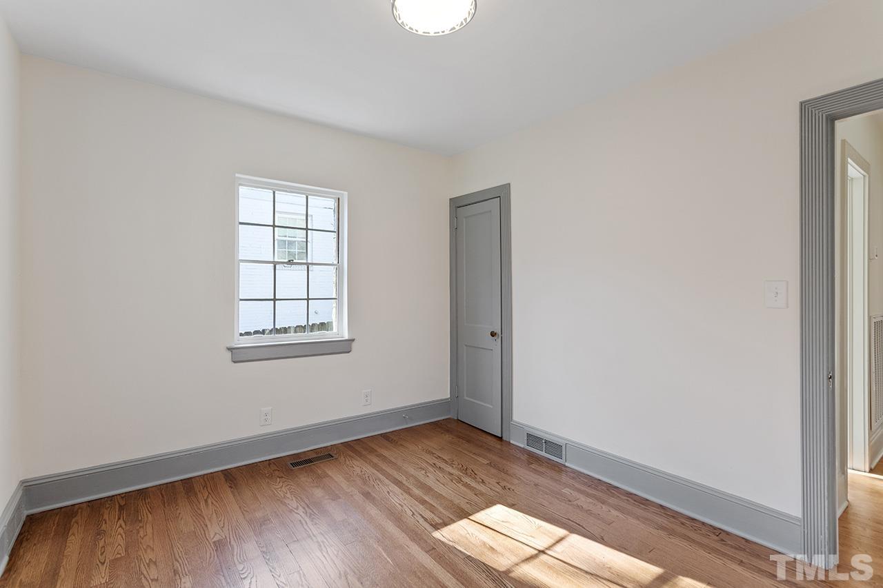 704 Dixie Trail Raleigh, NC 27607 - Photo 24 of 31 an empty room with wooden floor and windows
