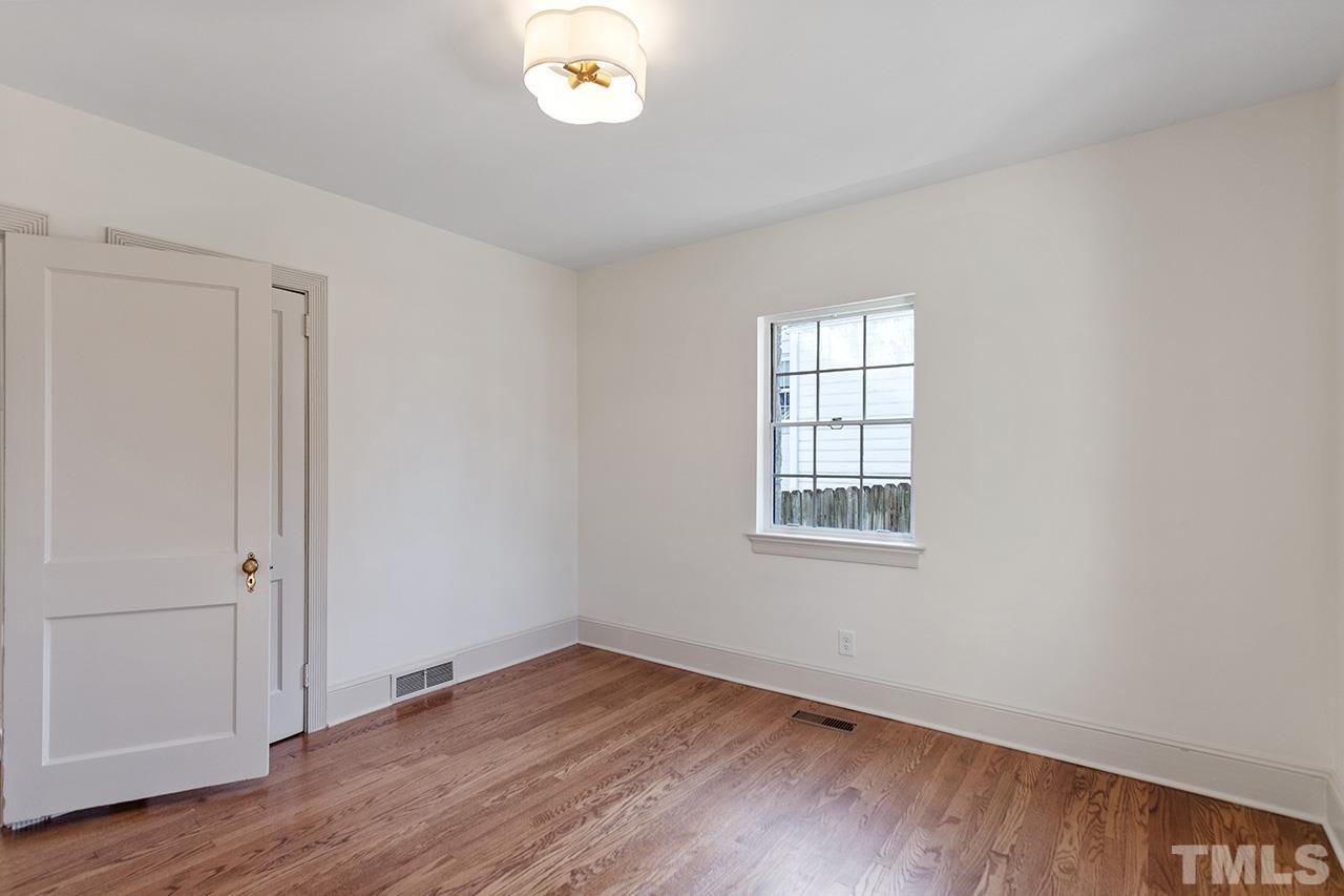 704 Dixie Trail Raleigh, NC 27607 - Photo 27 of 31 an empty room with wooden floor and windows
