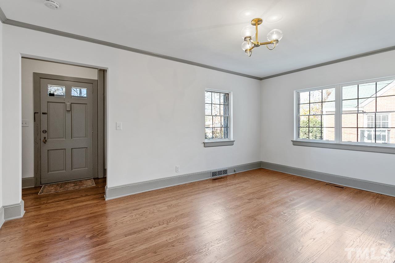 704 Dixie Trail Raleigh, NC 27607 - Photo 8 of 31 a view of an empty room with a window and wooden floor