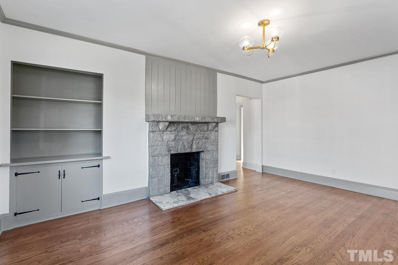 704 Dixie Trail Raleigh, NC 27607 - Photo 9 of 31 a view of an empty room with a fireplace and a window