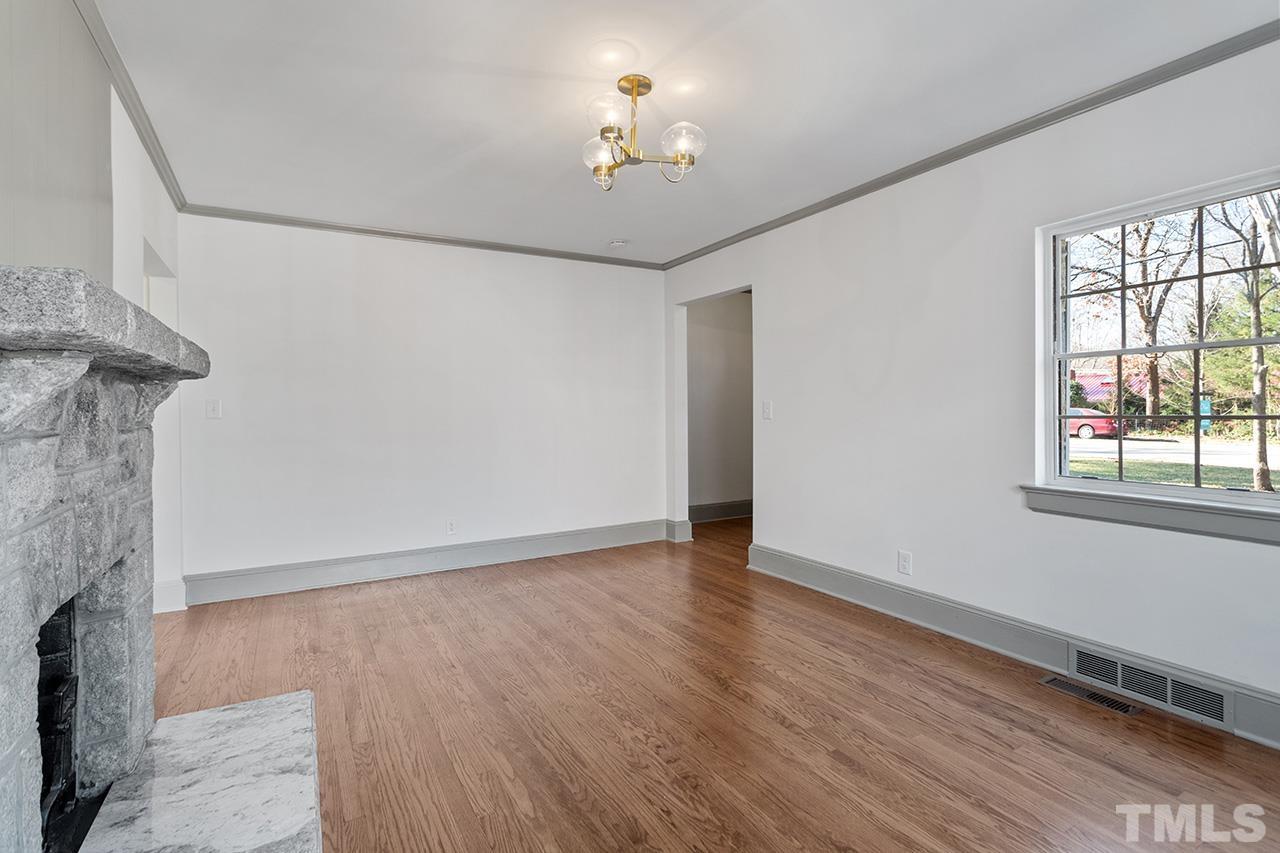 704 Dixie Trail Raleigh, NC 27607 - Photo 10 of 31 a view of an empty room with a window and wooden floor