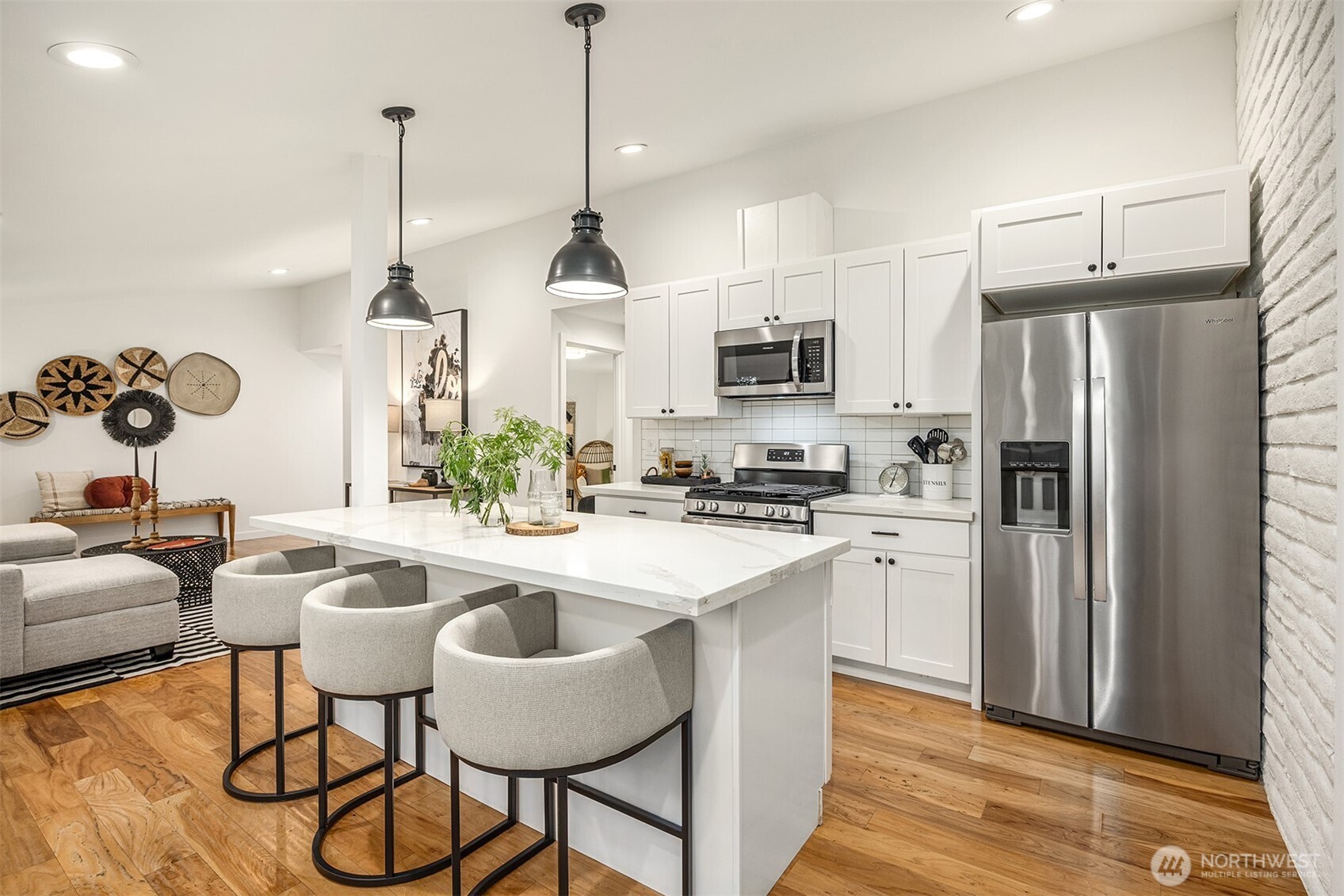 400 Southwest Forest Place Issaquah, WA 98027 - Photo 5 of 24 a kitchen with stainless steel appliances kitchen island granite countertop a refrigerator a stove a kitchen island a dining table and chairs with wooden floor