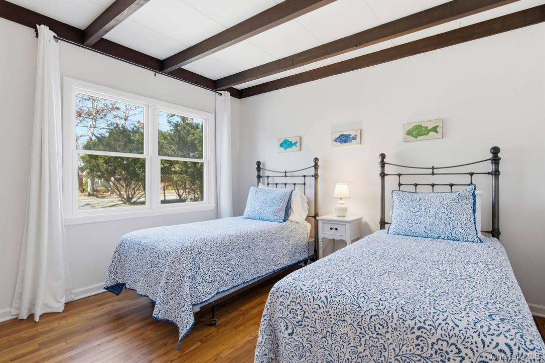 3 Foster Avenue Hampton Bays, NY 11946 - Photo 11 of 20 a bedroom with two beds and a large window