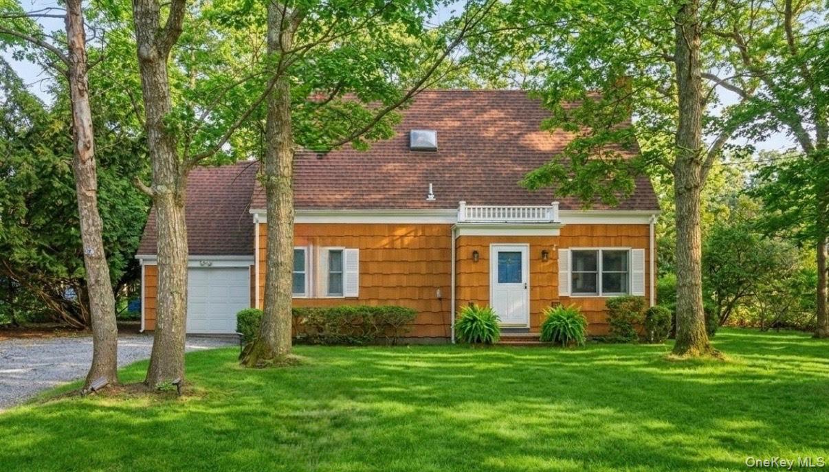 3 Foster Avenue Hampton Bays, NY 11946 - Photo 4 of 20 a front view of a house with a yard and garage