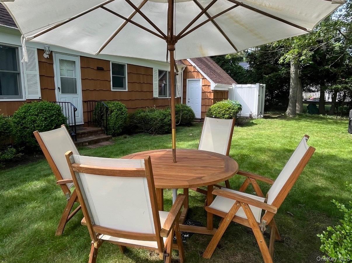 3 Foster Avenue Hampton Bays, NY 11946 - Photo 5 of 20 a view of a patio with table and chairs and potted plants
