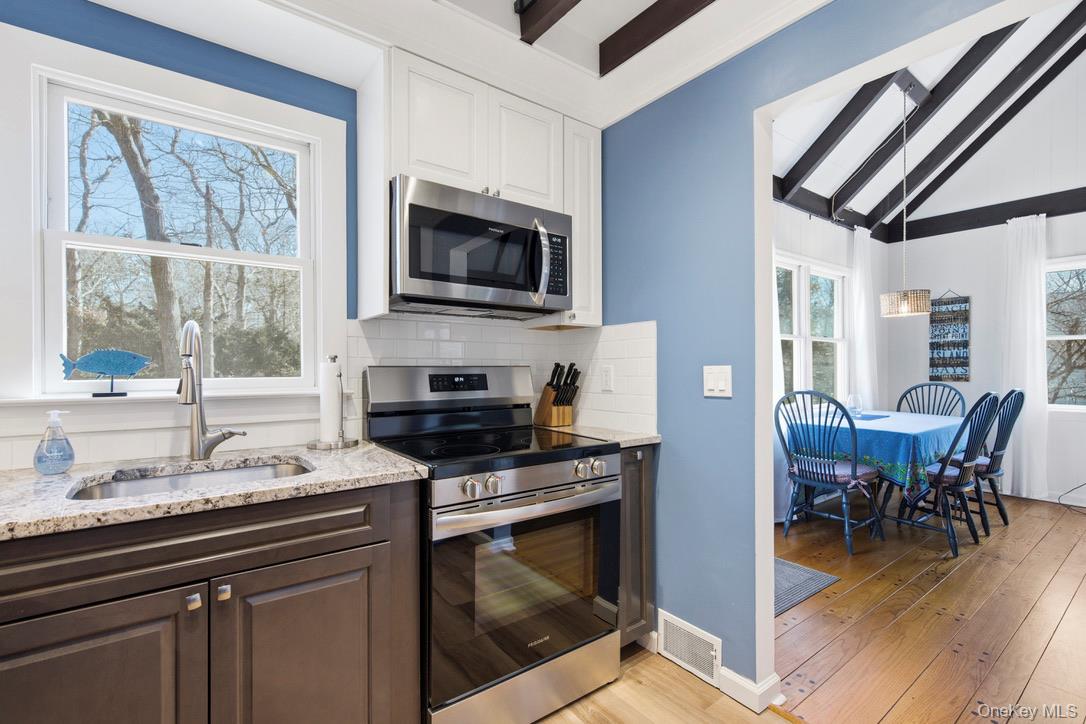 3 Foster Avenue Hampton Bays, NY 11946 - Photo 9 of 20 a kitchen with a stove a sink and a microwave