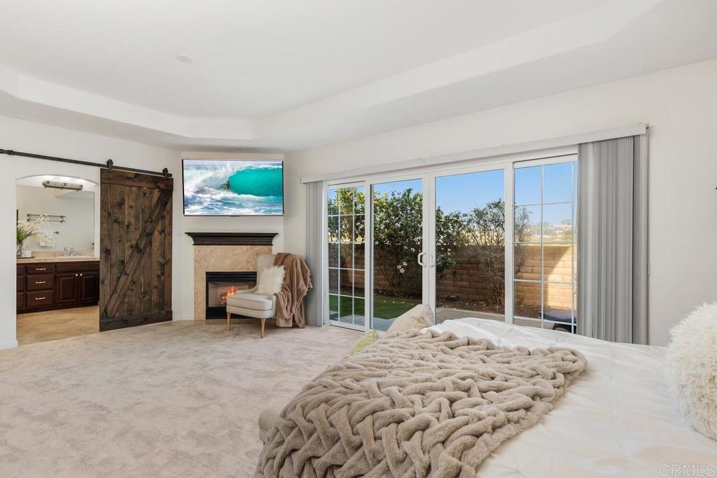 6456 Franciscan Road Carlsbad, CA 92011 - Photo 11 of 43 a bedroom with a bed and a fireplace