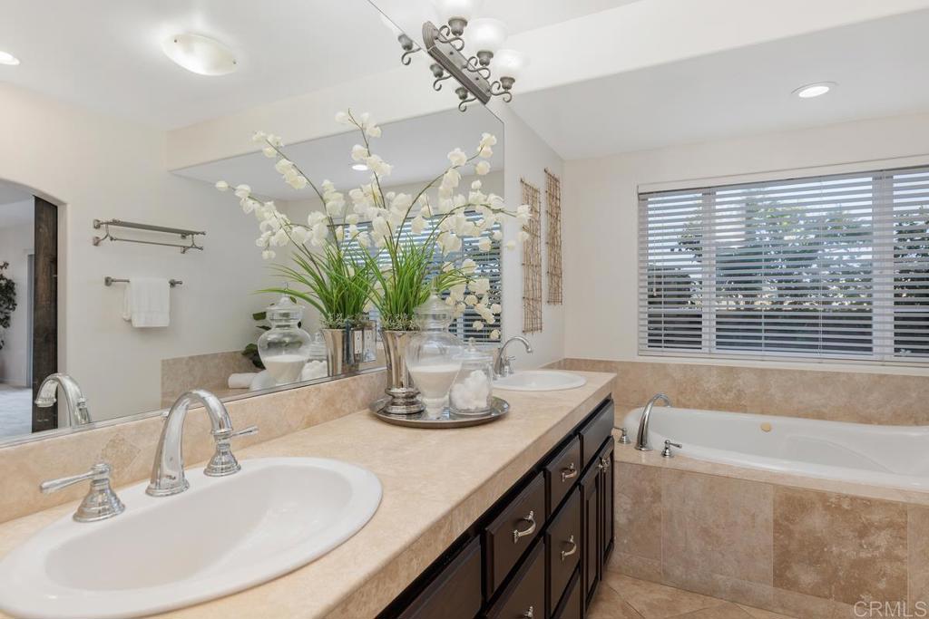 6456 Franciscan Road Carlsbad, CA 92011 - Photo 12 of 43 a bathroom with a double vanity sink a large mirror and a bathtub
