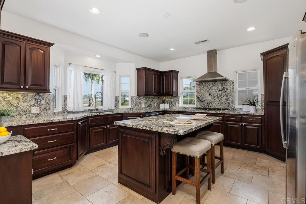 6456 Franciscan Road Carlsbad, CA 92011 - Photo 15 of 43 a kitchen with a stove a sink a refrigerator and chairs