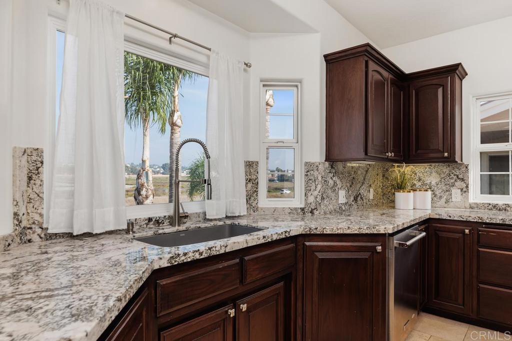 6456 Franciscan Road Carlsbad, CA 92011 - Photo 16 of 43 a kitchen with granite countertop a sink a stove and cabinets