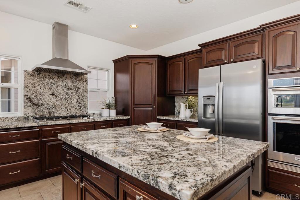 6456 Franciscan Road Carlsbad, CA 92011 - Photo 17 of 43 a kitchen with kitchen island granite countertop a sink and refrigerator