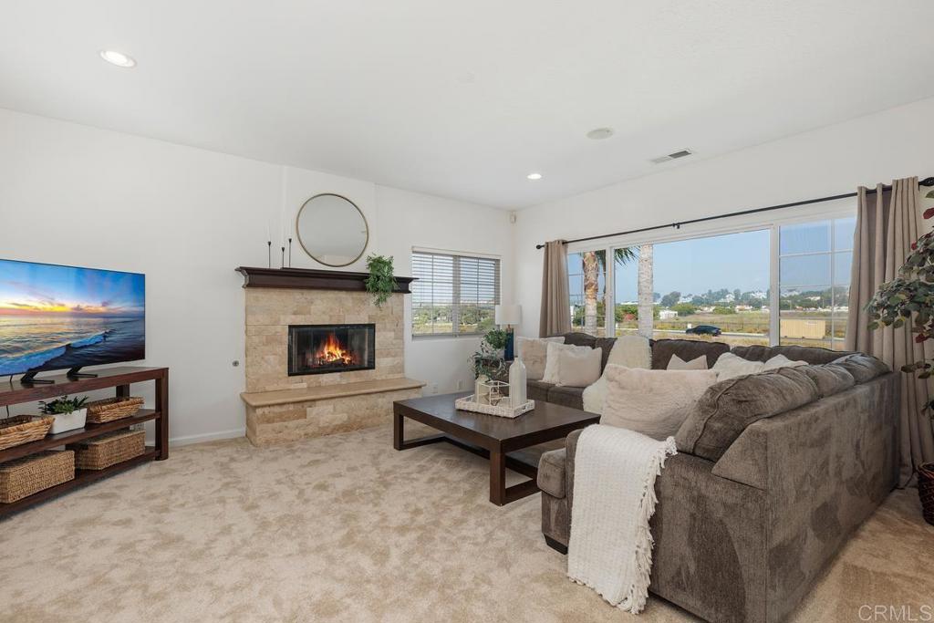 6456 Franciscan Road Carlsbad, CA 92011 - Photo 20 of 43 a living room with furniture a fireplace and a flat screen tv