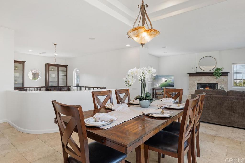 6456 Franciscan Road Carlsbad, CA 92011 - Photo 22 of 43 a dining room with wooden floor a chandelier a wooden table and chairs